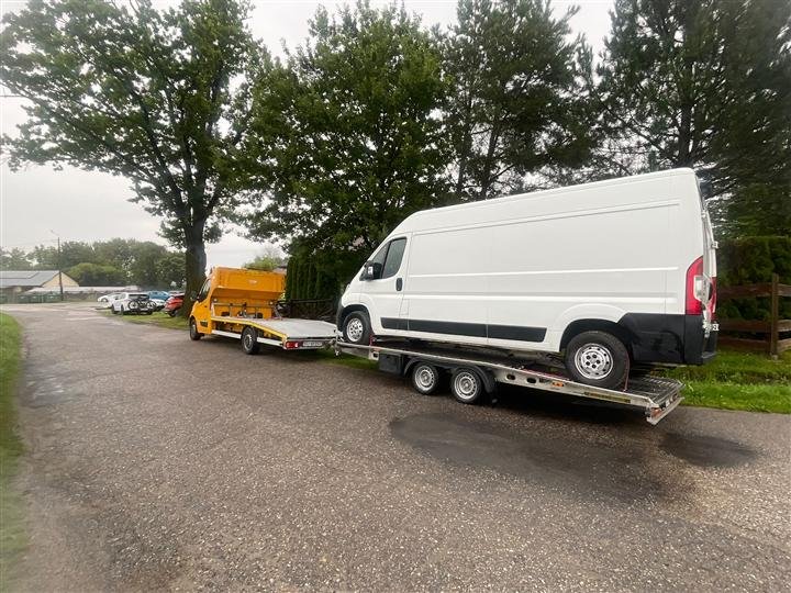 Transport dwóch pojazdów — laweta z przyczepą